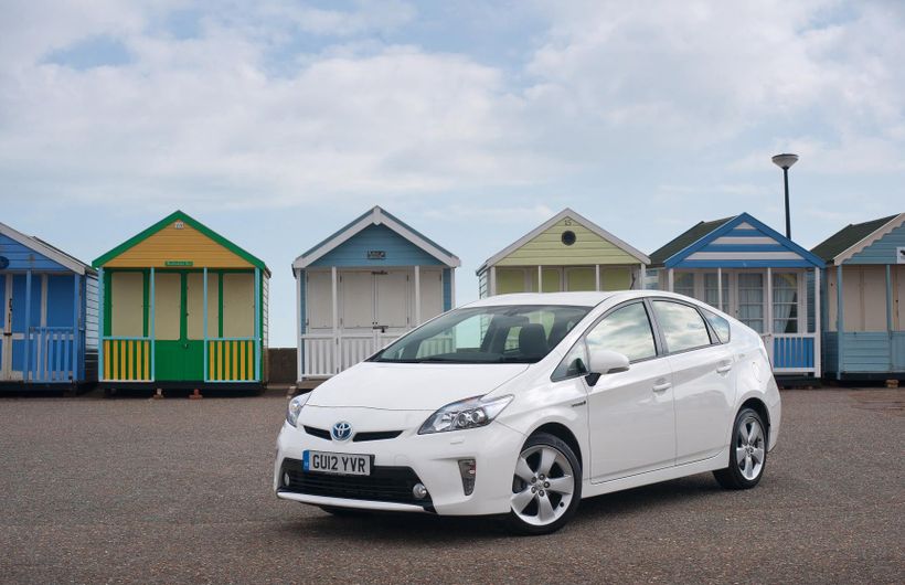 Toyota Prius parked in front of beach huts