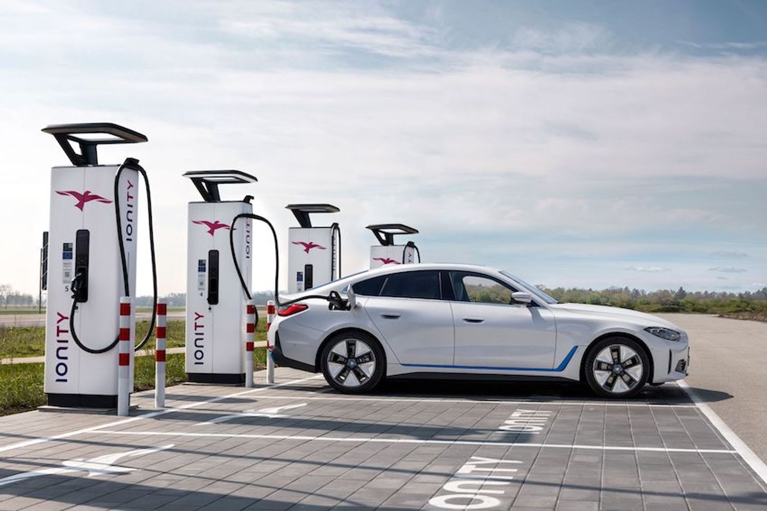 BMW i4 charging at an Ionity rapid charge unit, white car