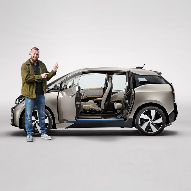 Tom Wookie Ford pointing at a gold BMW i3