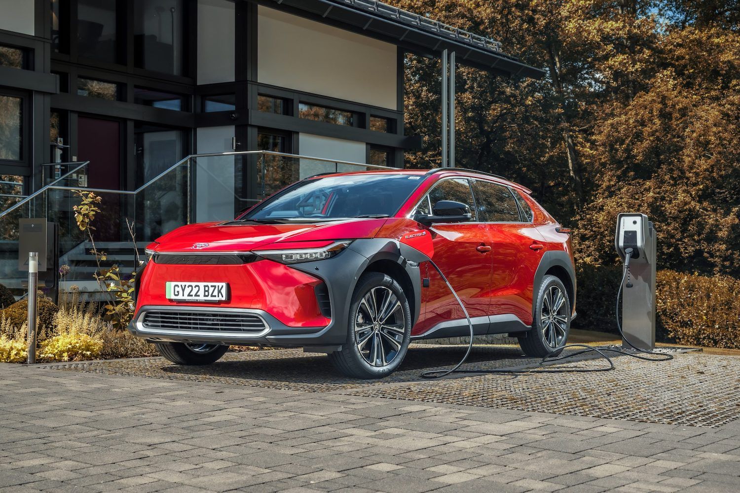 Toyota bZ4x charging shot, rear, red car, RHD UK registration